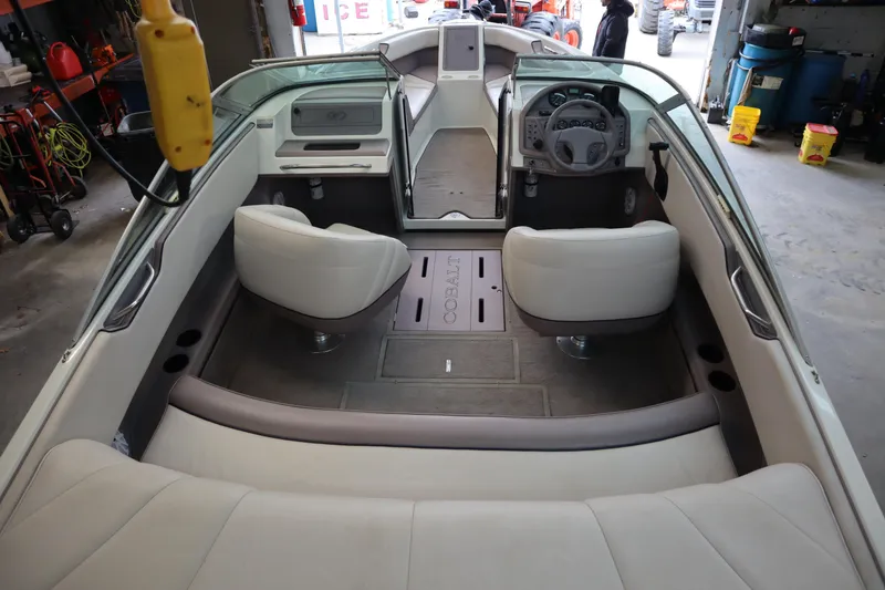 Slide: The Image of 1996 Cobalt 220 boat interior with white seating and steering wheel in a garage setting. - 5