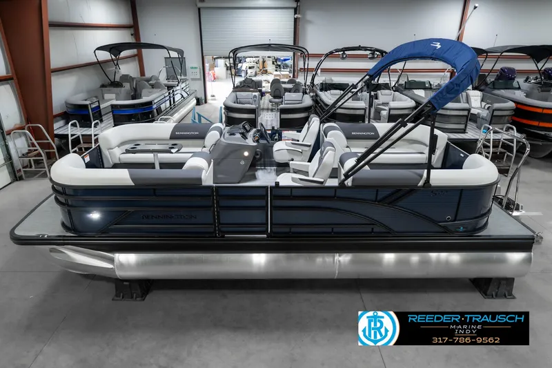 Slide: The Image of 2025 Bennington 22 SSR pontoon boat in showroom, featuring sleek design and blue canopy. - 1