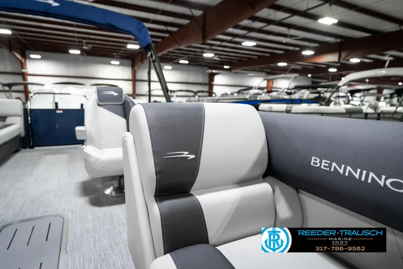 Slide: The Image of 2025 Bennington 22 SSR pontoon boat interior with gray and white seating in showroom. - 26