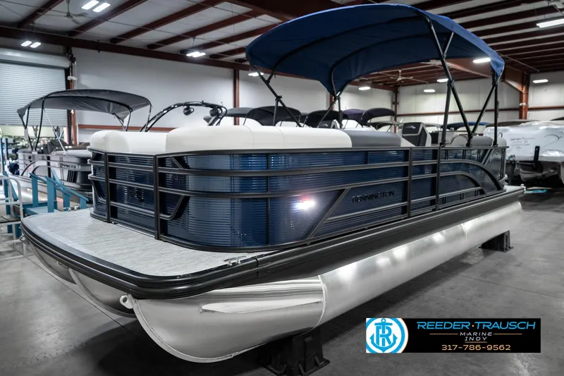 Slide: The Image of 2025 Bennington 22 SSR pontoon boat with blue canopy in showroom. - 3