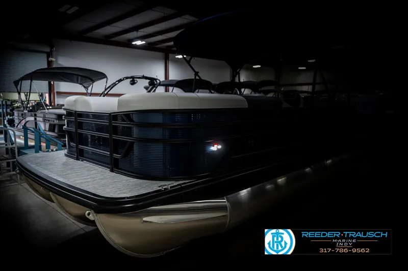 Slide: The Image of 2025 Bennington 22 SSR pontoon boat in a dimly lit showroom. - 4