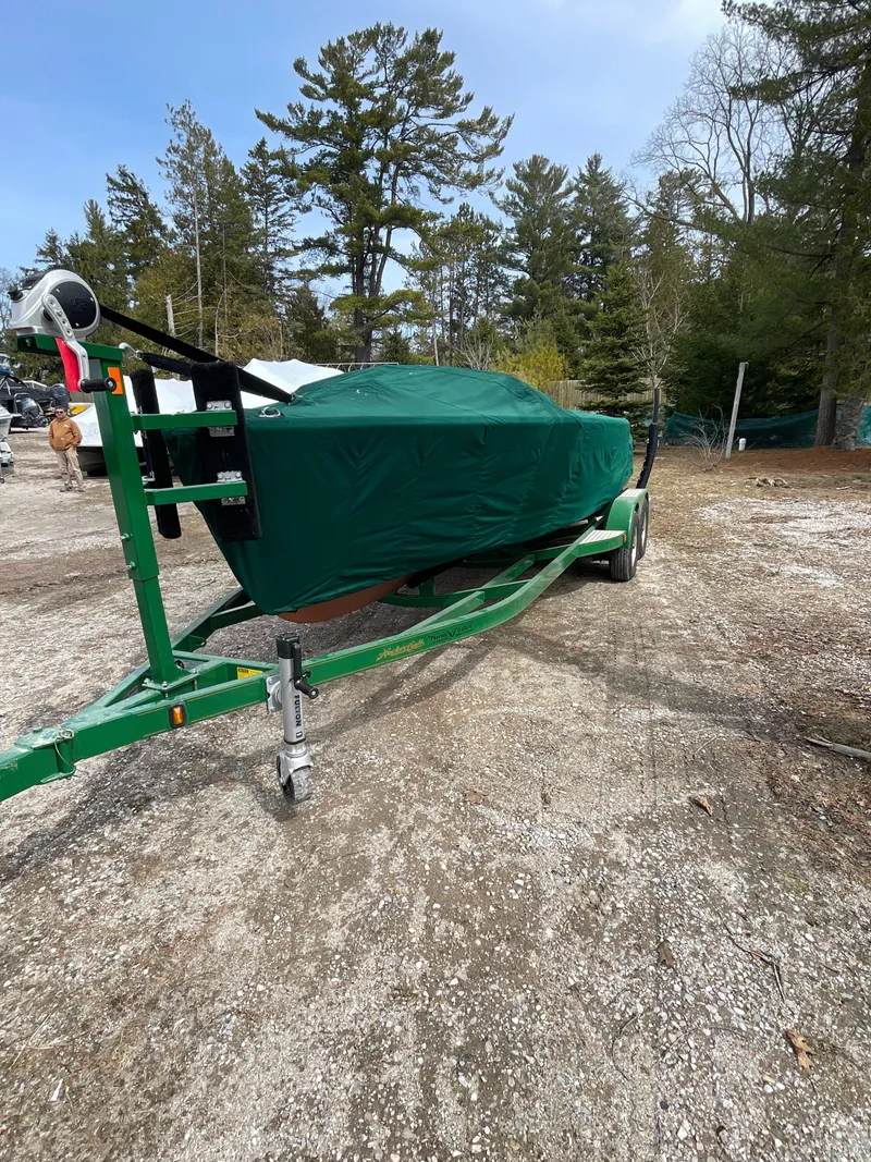 Slide: The Image of 1951 Hacker-Craft 22 Utility boat covered on a trailer in a wooded area. - 11