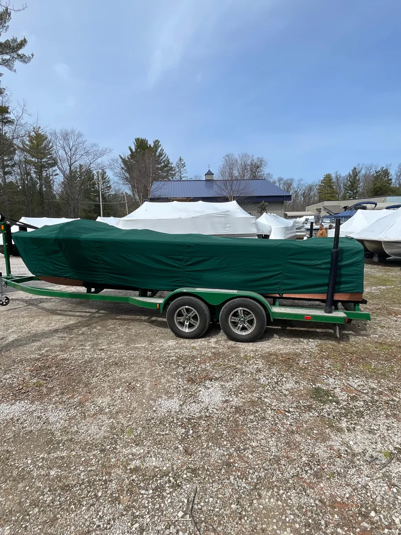 Slide: The Image of 1951 Hacker-Craft 22 Utility boat covered on a trailer in a yard. - 12