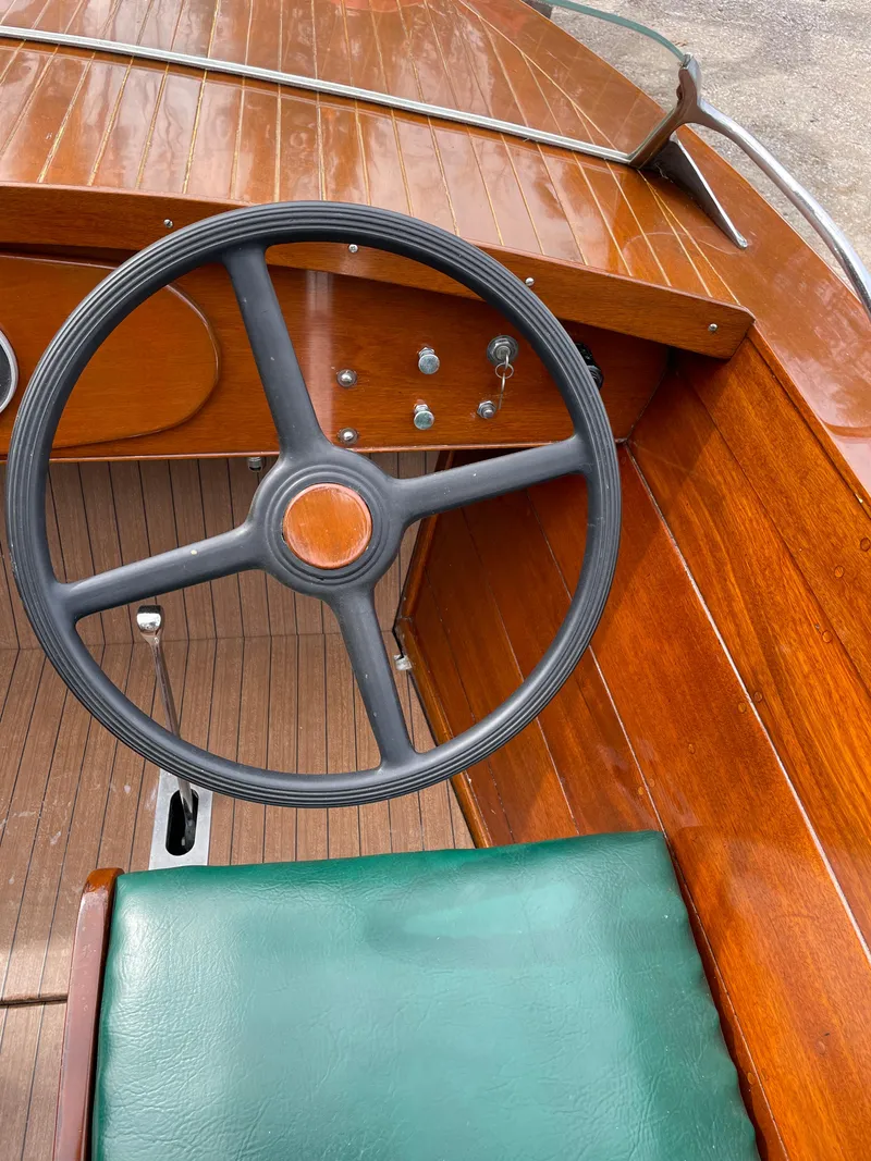 Slide: The Image of 1951 Hacker-Craft 22 Utility boat interior with wooden dashboard and green seat. - 3