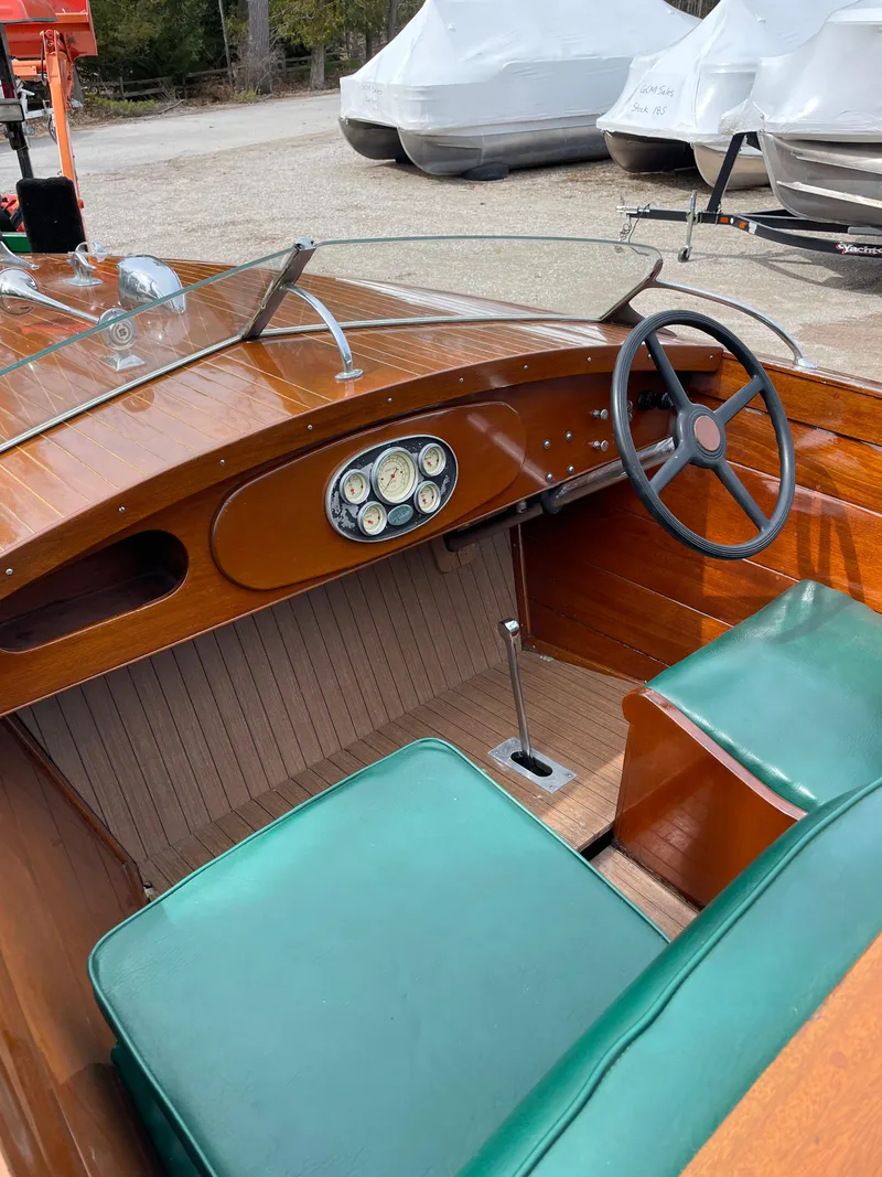 Slide: The Image of 1951 Hacker-Craft 22 Utility boat interior with green seats and wooden dashboard. - 7