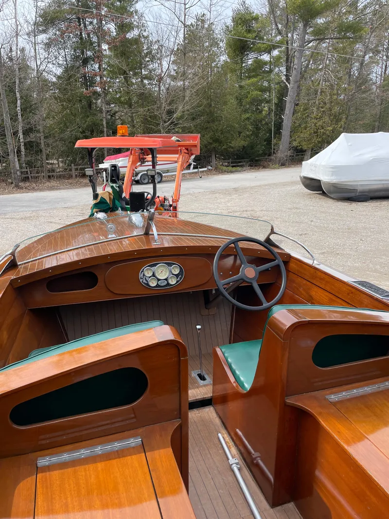 Slide: The Image of 1951 Hacker-Craft 22 Utility boat with wooden interior and steering wheel, parked outdoors. - 8