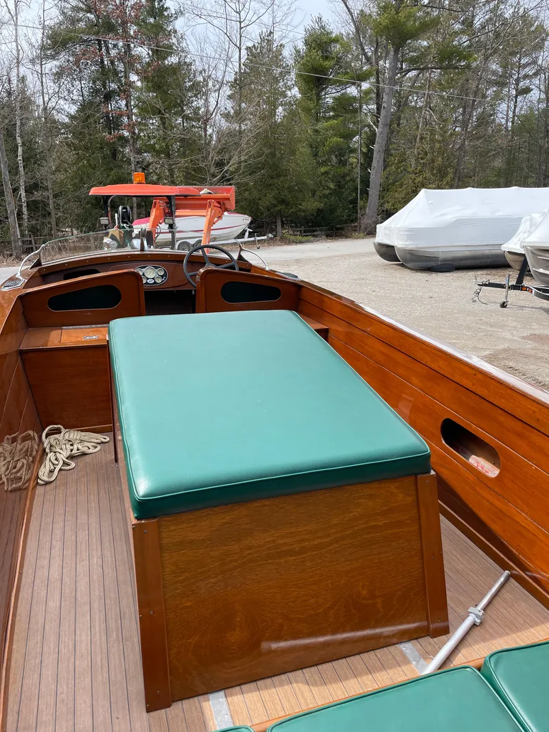 Slide: The Image of 1951 Hacker-Craft 22 Utility boat with green seating and wooden interior, docked outdoors. - 9