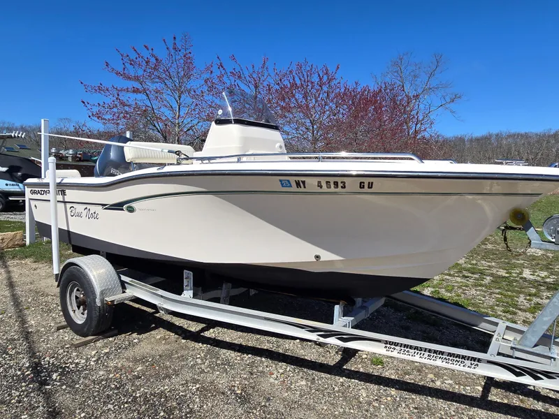Slide: The Image of 2010 Grady-White Sportsman 180 boat on trailer, parked outdoors under clear blue sky. - 0