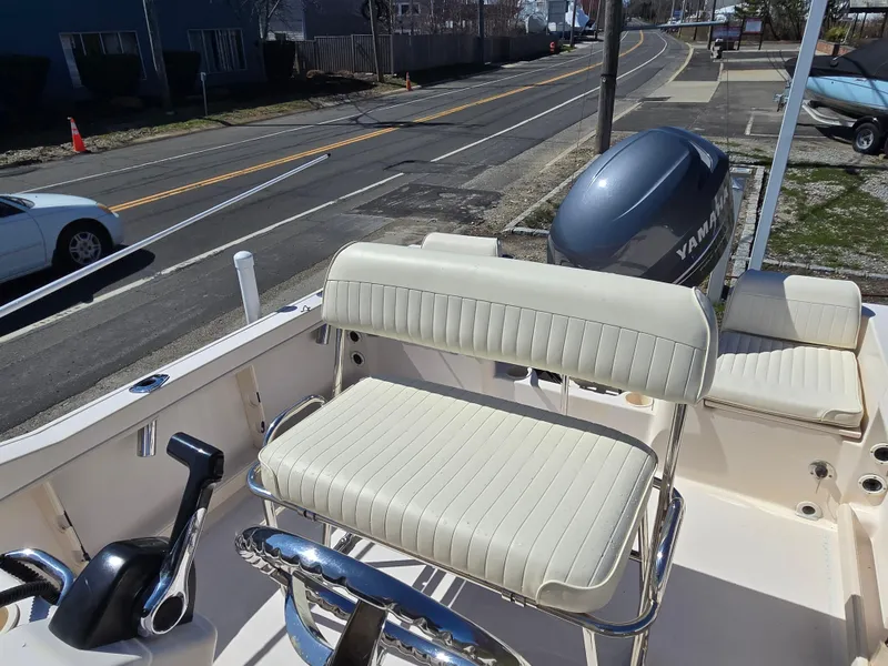Slide: The Image of 2010 Grady-White Sportsman 180 boat interior with Yamaha outboard motor, parked near a road. - 3