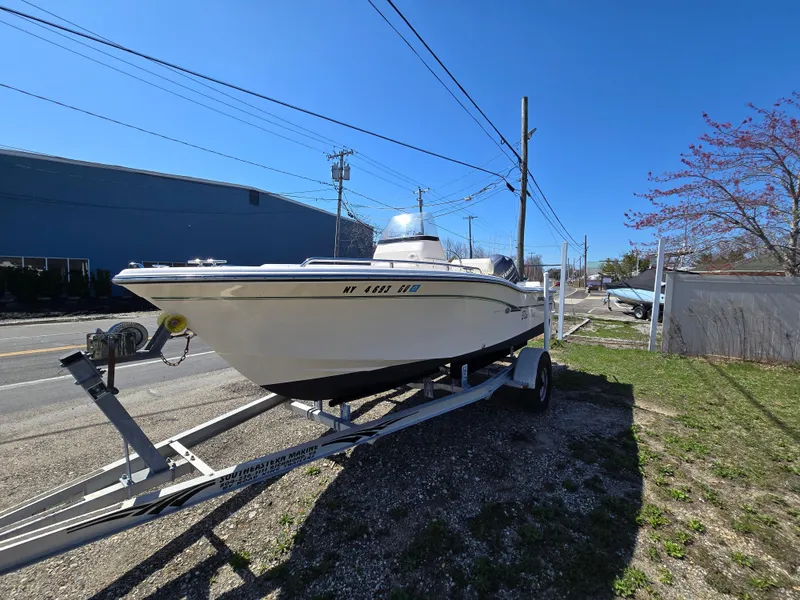 Slide: The Image of 2010 Grady-White Sportsman 180 boat on trailer, parked outdoors under clear blue sky. - 7