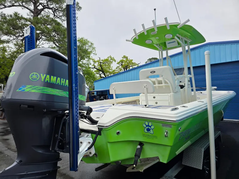 Slide: The Image of 2015 Pathfinder 2600 HPS boat with Yamaha engine, vibrant green and white design, parked outdoors. - 13
