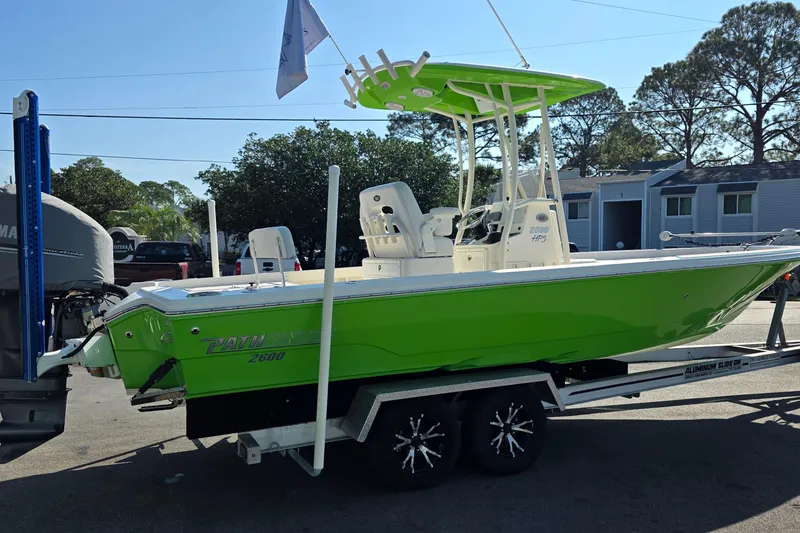 Slide: The Image of 2015 Pathfinder 2600 HPS boat in vibrant green on a trailer, parked outdoors. - 2