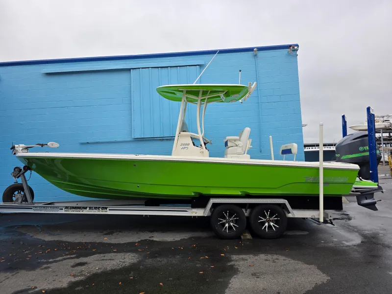 Slide: The Image of 2015 Pathfinder 2600 HPS boat in vibrant green on a trailer, parked by a blue building. - 5