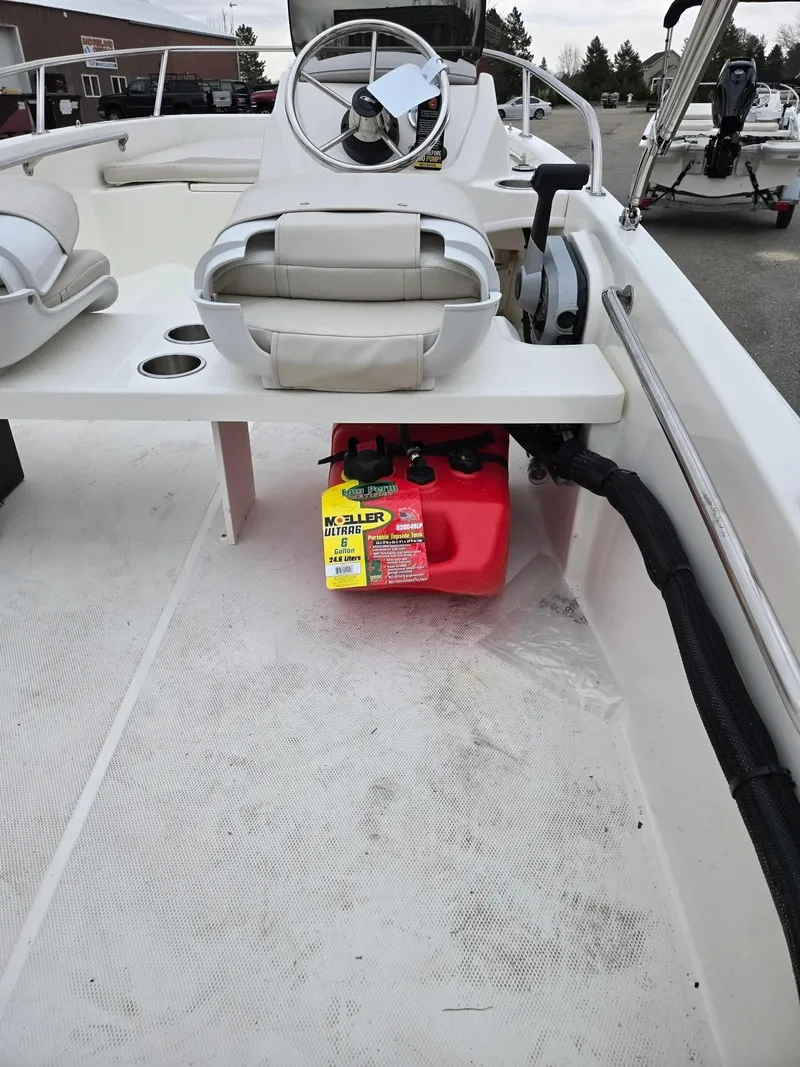 Slide: The Image of 2025 Boston Whaler 130 Super Sport interior with steering wheel and red fuel tank. - 5