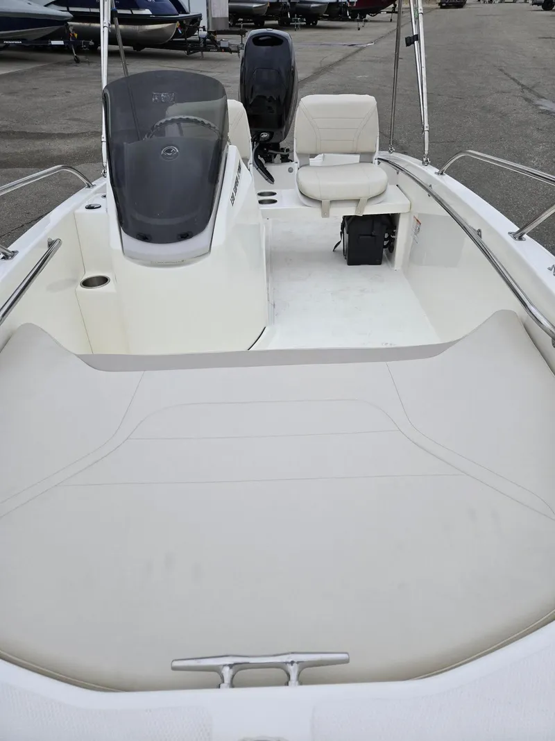 Slide: The Image of 2025 Boston Whaler 130 Super Sport boat interior with seating and console. - 9