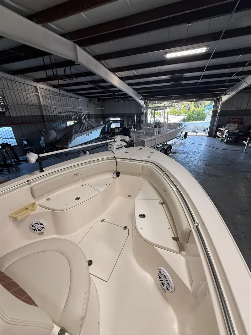 Slide: The Image of 2022 Cobia 237 CC boat in a spacious indoor storage facility. - 10