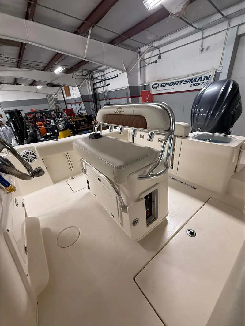 Slide: The Image of 2022 Cobia 237 CC boat interior with seating and storage in a showroom. - 12