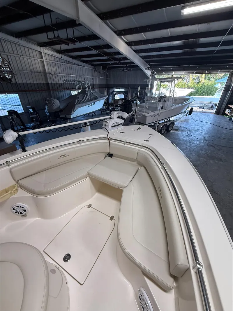 Slide: The Image of 2022 Cobia 237 CC boat interior in a storage facility with other boats. - 13