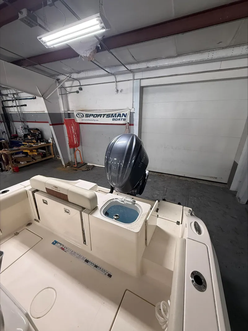Slide: The Image of 2022 Cobia 237 CC boat interior with motor in a garage setting. - 14