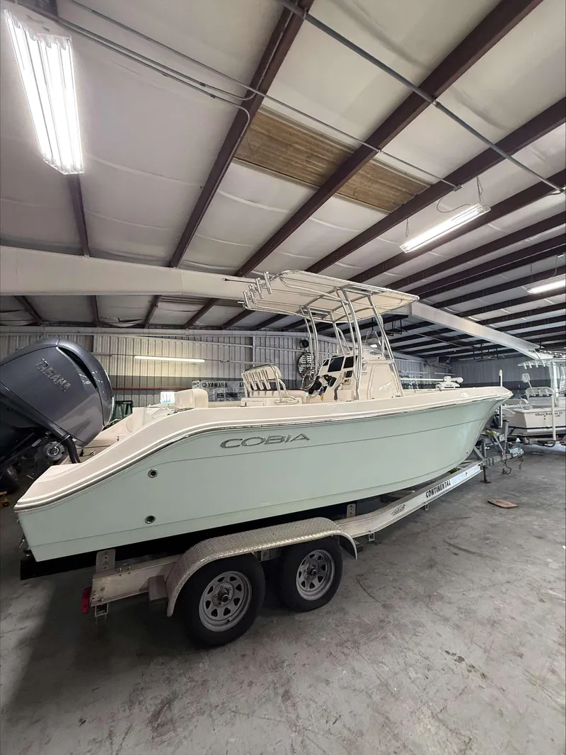 Slide: The Image of 2022 Cobia 237 CC boat on trailer in indoor storage facility. - 2