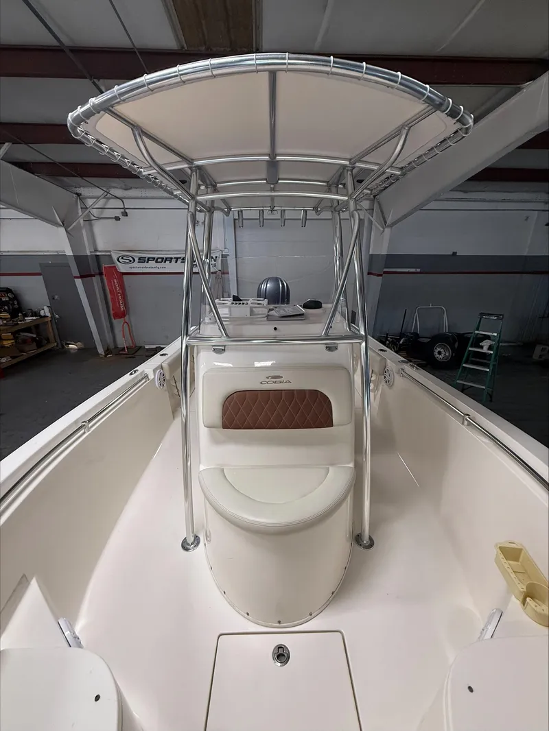 Slide: The Image of 2022 Cobia 237 CC boat interior with T-top and seating in a showroom. - 4