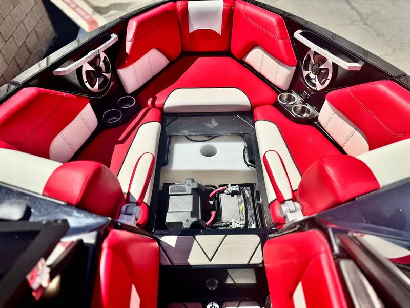Slide: The Image of 2021 Malibu Wakesetter 25 LSV interior with red and white seating, cup holders, and speakers. - 18