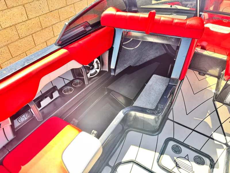 Slide: The Image of 2021 Malibu Wakesetter 25 LSV interior with red and gray seating, cup holders, and sleek design. - 21