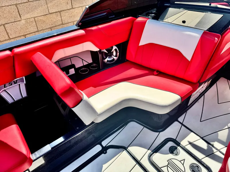 Slide: The Image of 2021 Malibu Wakesetter 25 LSV interior with red and white seating, cup holders, and sleek design. - 22