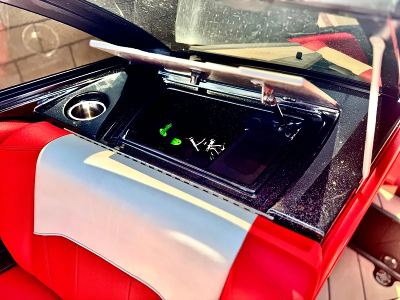 Slide: The Image of Interior of 2021 Malibu Wakesetter 25 LSV with red and gray seating, open storage compartment. - 23