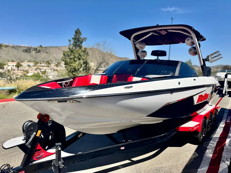 Slide: The Image of 2021 Malibu Wakesetter 25 LSV boat on trailer, sleek design, red and white accents. - 3