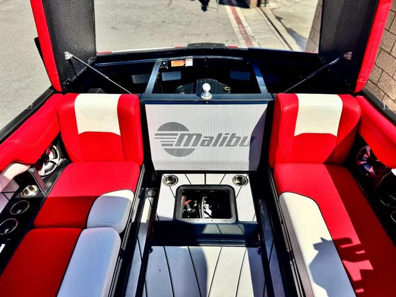 Slide: The Image of 2021 Malibu Wakesetter 25 LSV interior with red and white seating, open storage compartments. - 30