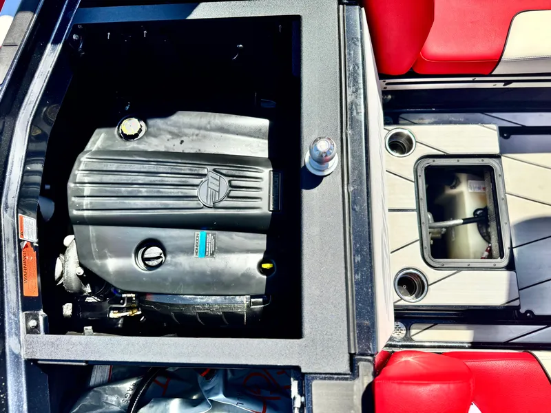 Slide: The Image of 2021 Malibu Wakesetter 25 LSV engine compartment with red seating and storage area. - 31