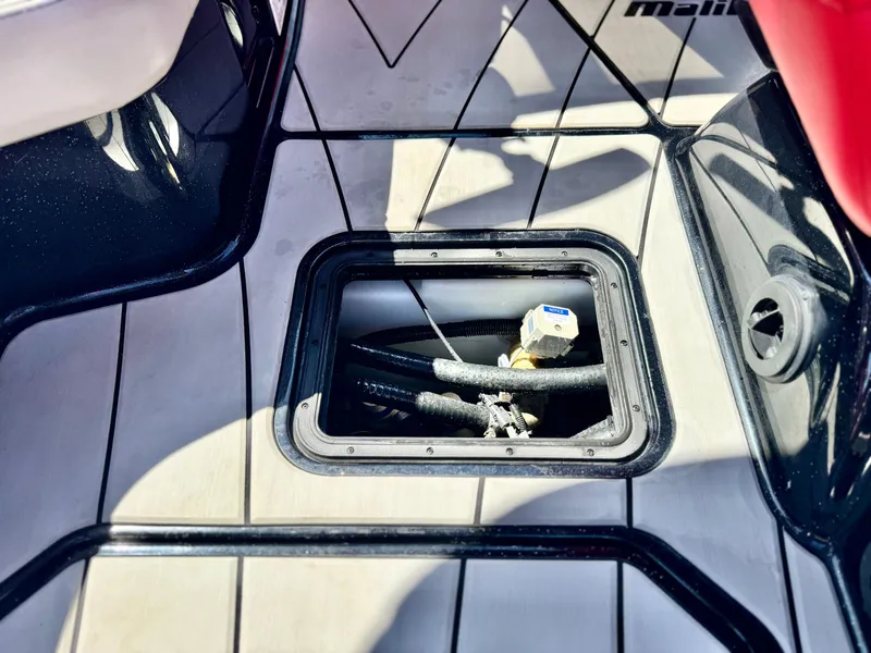 Slide: The Image of 2021 Malibu Wakesetter 25 LSV boat interior with open hatch and visible components. - 32
