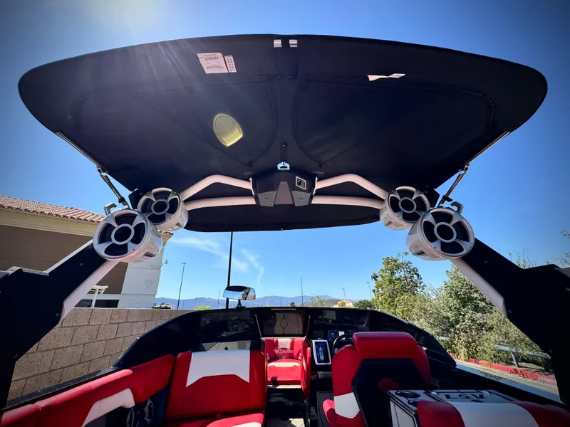 Slide: The Image of 2021 Malibu Wakesetter 25 LSV interior with speakers and red seating under a sunny sky. - 33