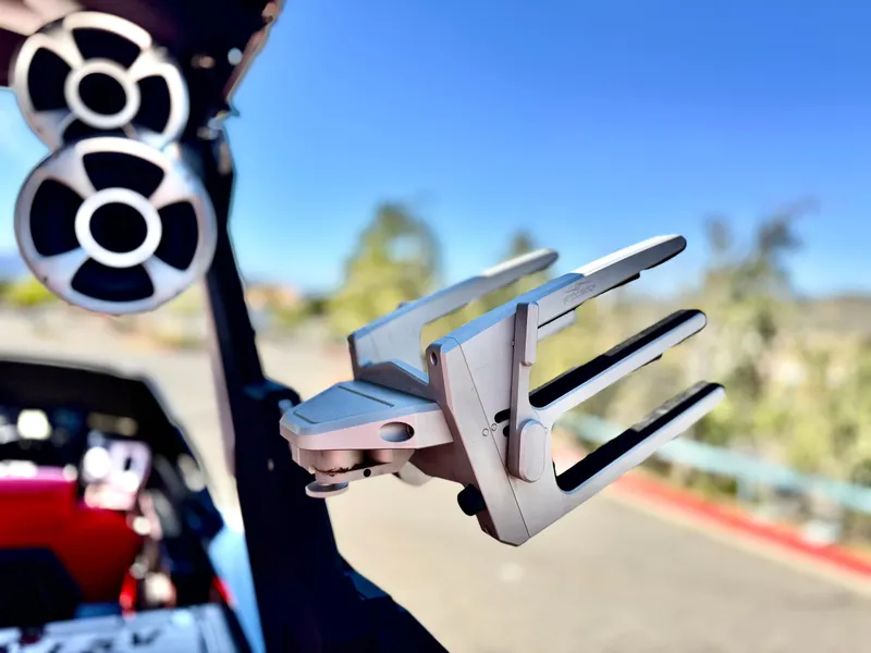 Slide: The Image of 2021 Malibu Wakesetter 25 LSV boat with wakeboard rack and speakers, sunny day. - 36