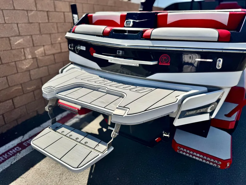 Slide: The Image of 2021 Malibu Wakesetter 25 LSV boat rear view with swim platform and red accents. - 7