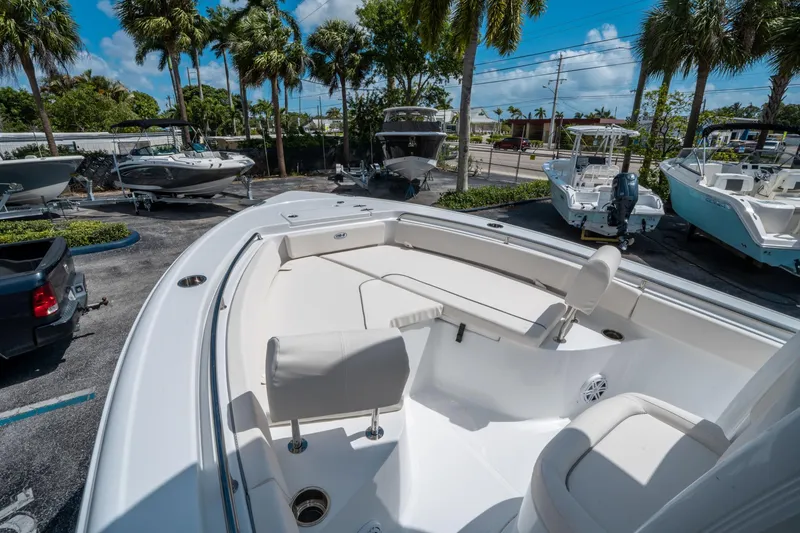 Slide: The Image of 2025 Sea Hunt Ultra 229 boat displayed outdoors with palm trees and clear sky. - 22