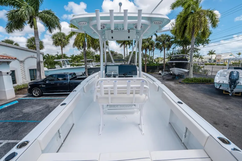 Slide: The Image of 2025 Sea Hunt Ultra 229 boat in a tropical setting with palm trees and clear skies. - 9