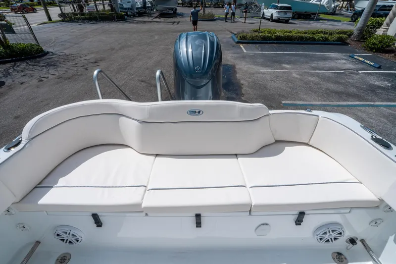Slide: The Image of 2025 Sea Hunt Ultra 229 boat with white cushioned seating and outboard motor. - 10