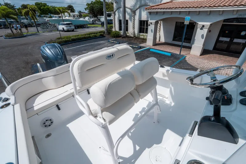 Slide: The Image of 2025 Sea Hunt Ultra 229 boat interior with white seating and steering wheel. - 19
