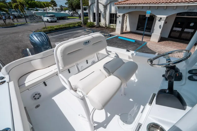 Slide: The Image of 2025 Sea Hunt Ultra 229 boat interior with white seating and steering wheel. - 20