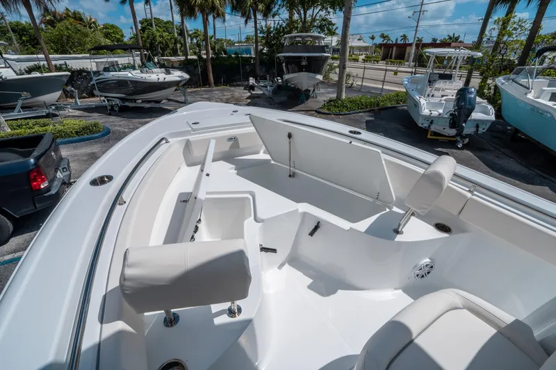 Slide: The Image of 2025 Sea Hunt Ultra 229 boat interior with seating and storage, displayed outdoors. - 26