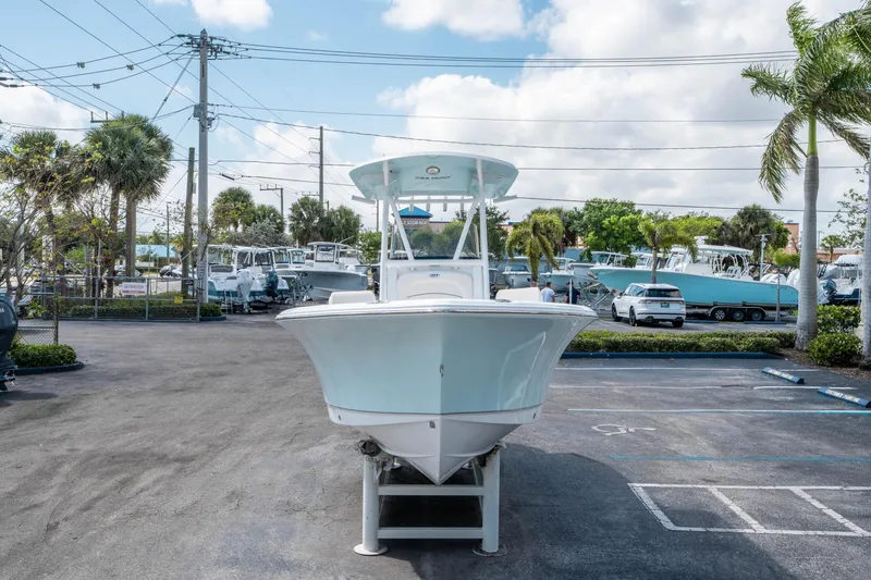 Slide: The Image of 2025 Sea Hunt Ultra 229 boat displayed in a parking lot with palm trees and cloudy sky. - 7