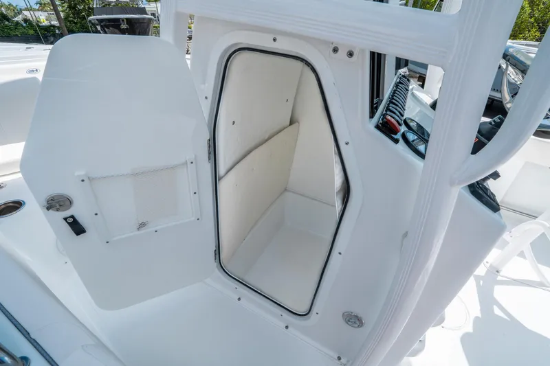 Slide: The Image of 2025 Sea Hunt Ultra 229 boat interior storage compartment with open door. - 21