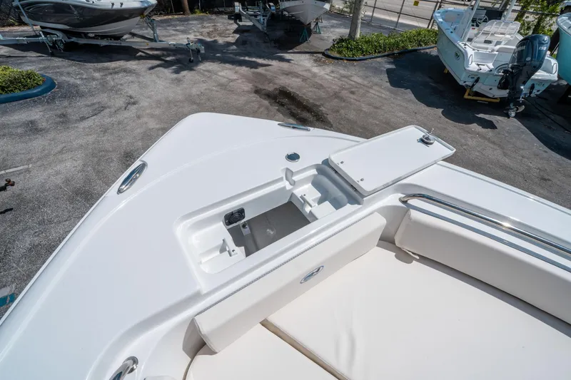 Slide: The Image of 2025 Sea Hunt Ultra 229 boat deck with storage compartment open, showcasing sleek design. - 28