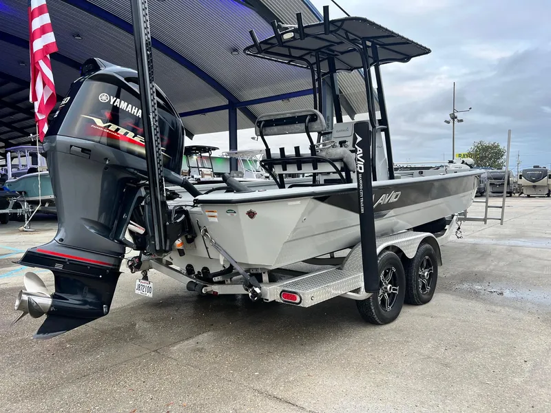 Slide: The Image of 2023 Avid 23 Mag boat with Yamaha engine on trailer, parked outdoors. - 12