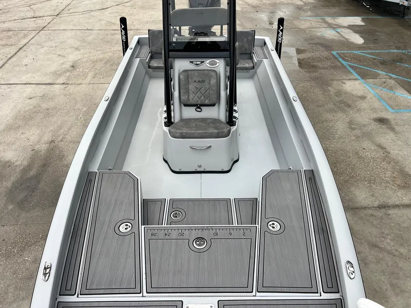 Slide: The Image of 2023 Avid 23 Mag boat interior with gray deck and seating, parked on concrete. - 16