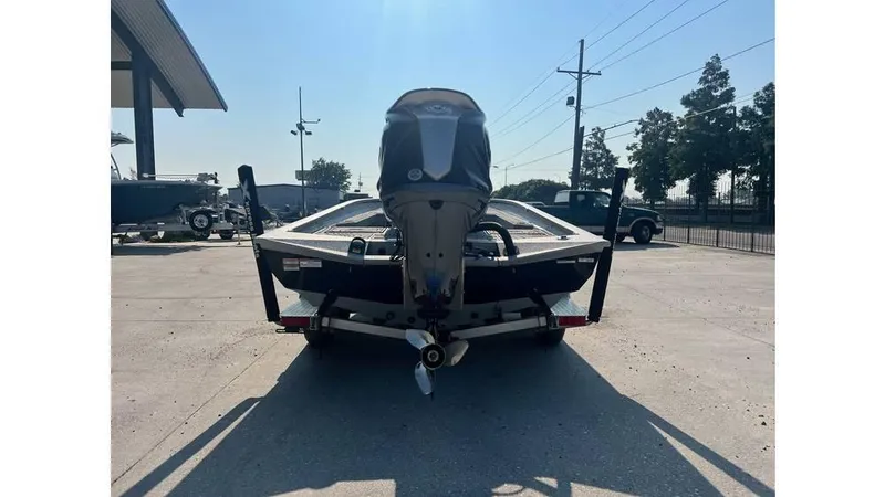 Slide: The Image of 2023 Express H22B boat rear view with outboard motor in a parking area. - 3