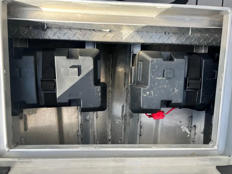 Slide: The Image of Battery compartments in a 2022 Hanko 185 CCLS boat, featuring secure black battery boxes. - 17