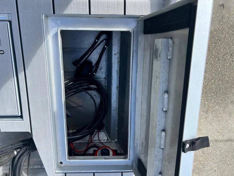 Slide: The Image of Open storage compartment on a 2022 Hanko 185 CCLS boat, containing cables and equipment. - 4